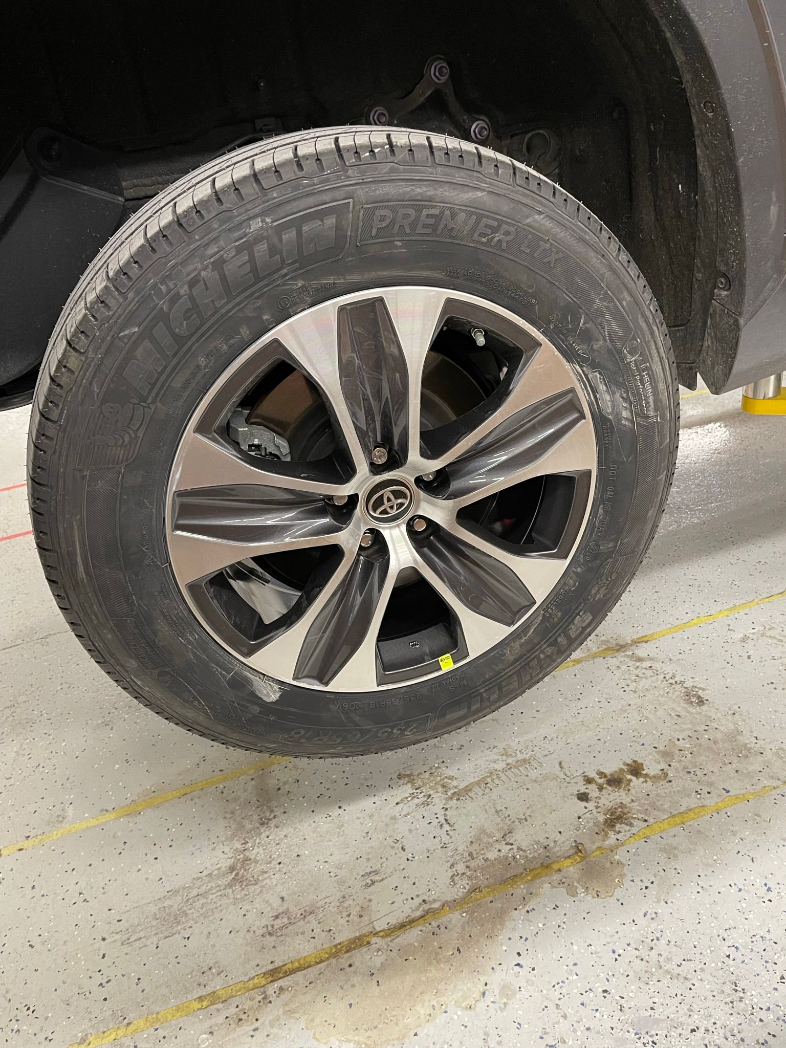 A close up of a tire on a car in a garage.