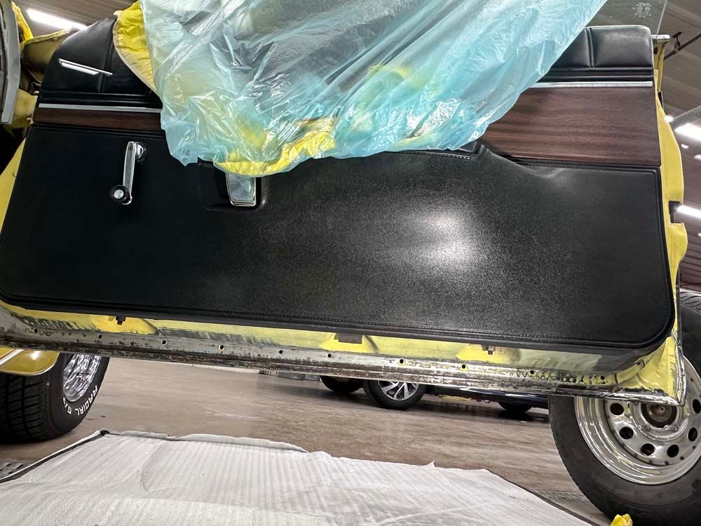 The door of a car is being painted yellow and black