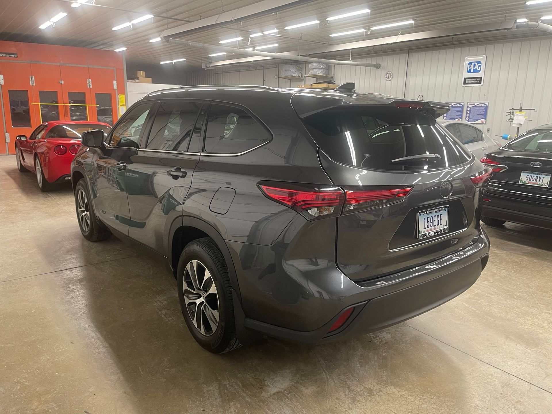 A gray toyota highlander is parked in a garage.