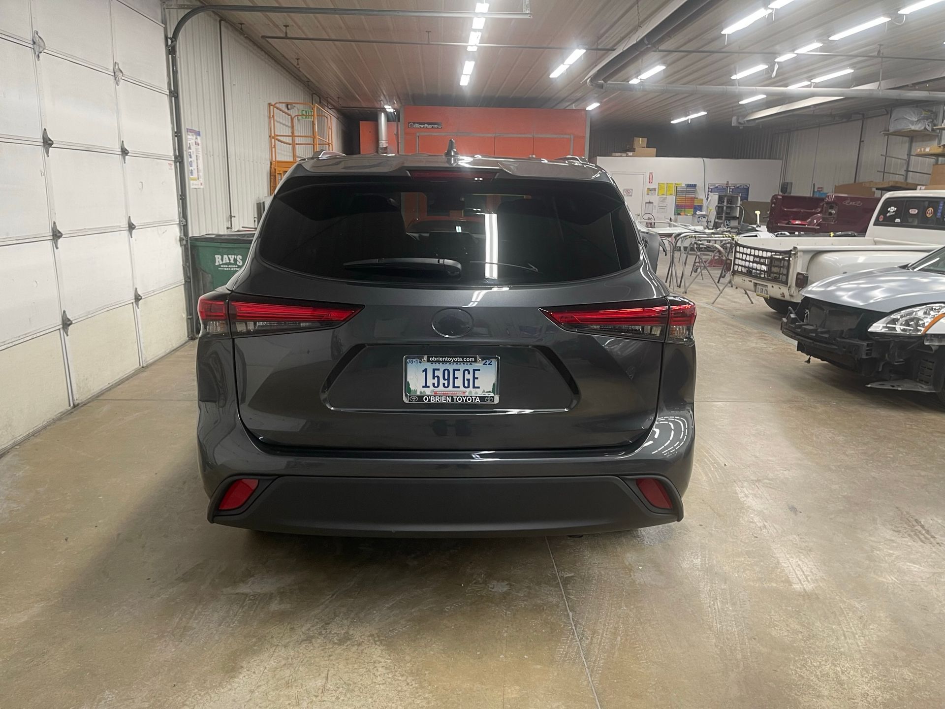A gray suv is parked in a garage next to a garage door.