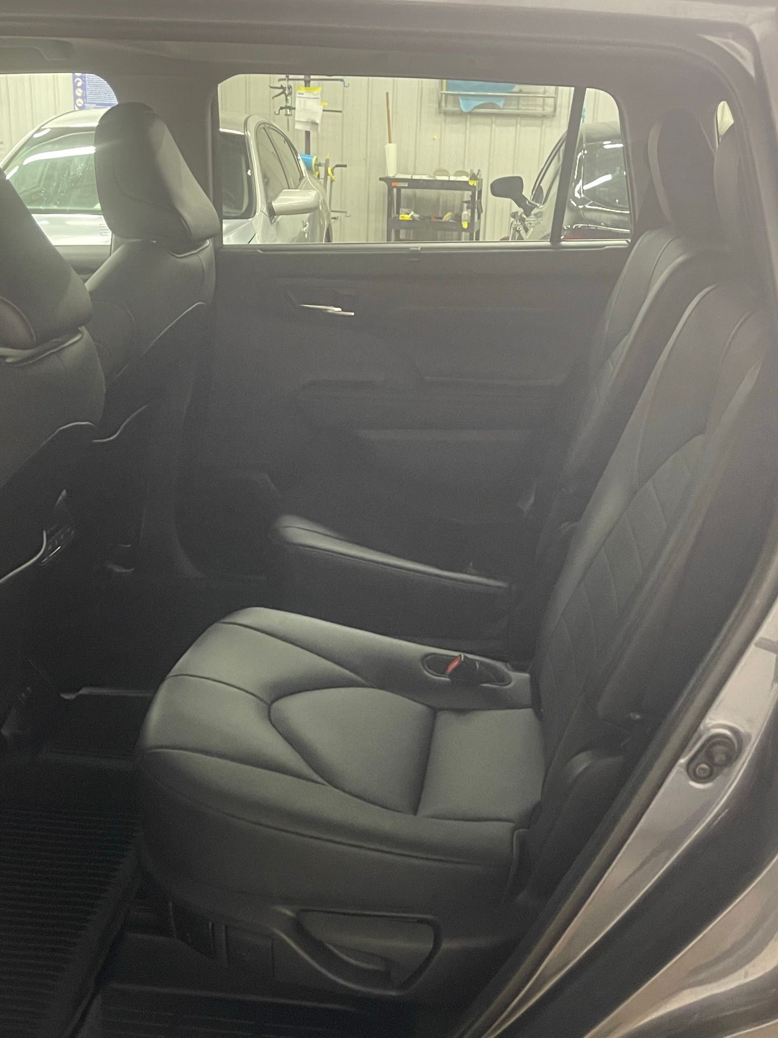 The back seat of a car with the door open.