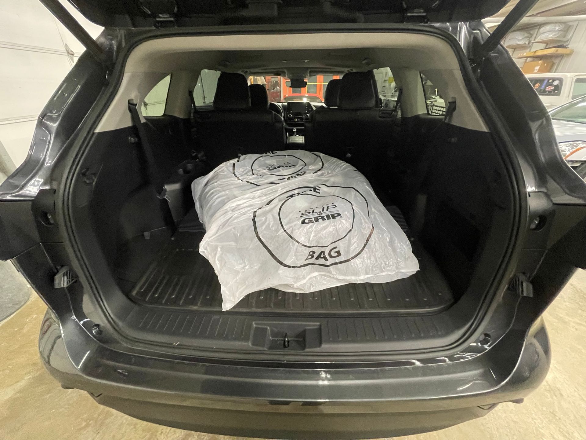 The back of a car with the trunk open and a bag in it.