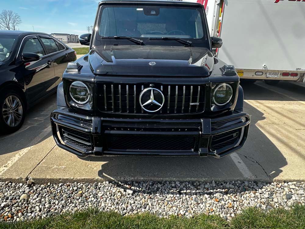 Black Mercedes-Benz G-Class SUV parked outside, facing forward.
