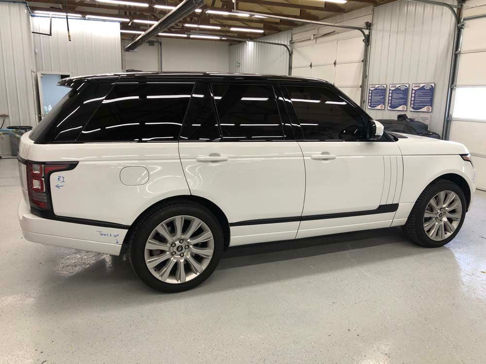 A white range rover is parked in a garage.