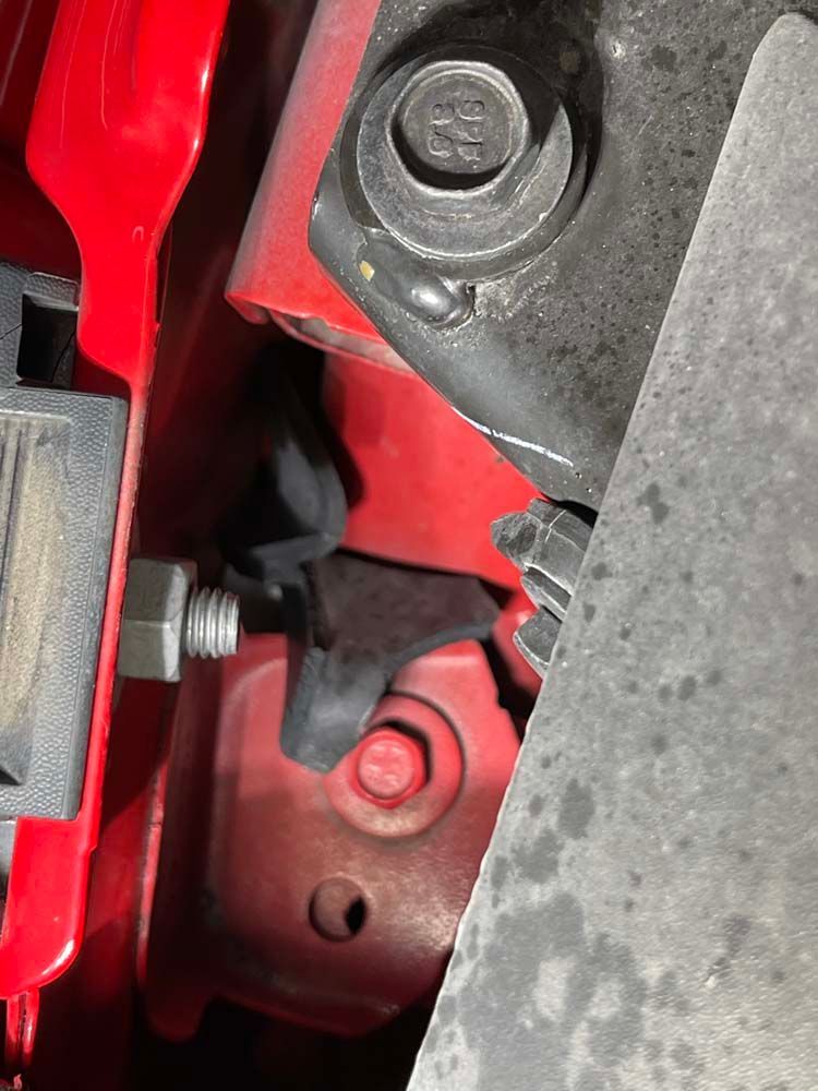 A close up of a red car with a screw in it.