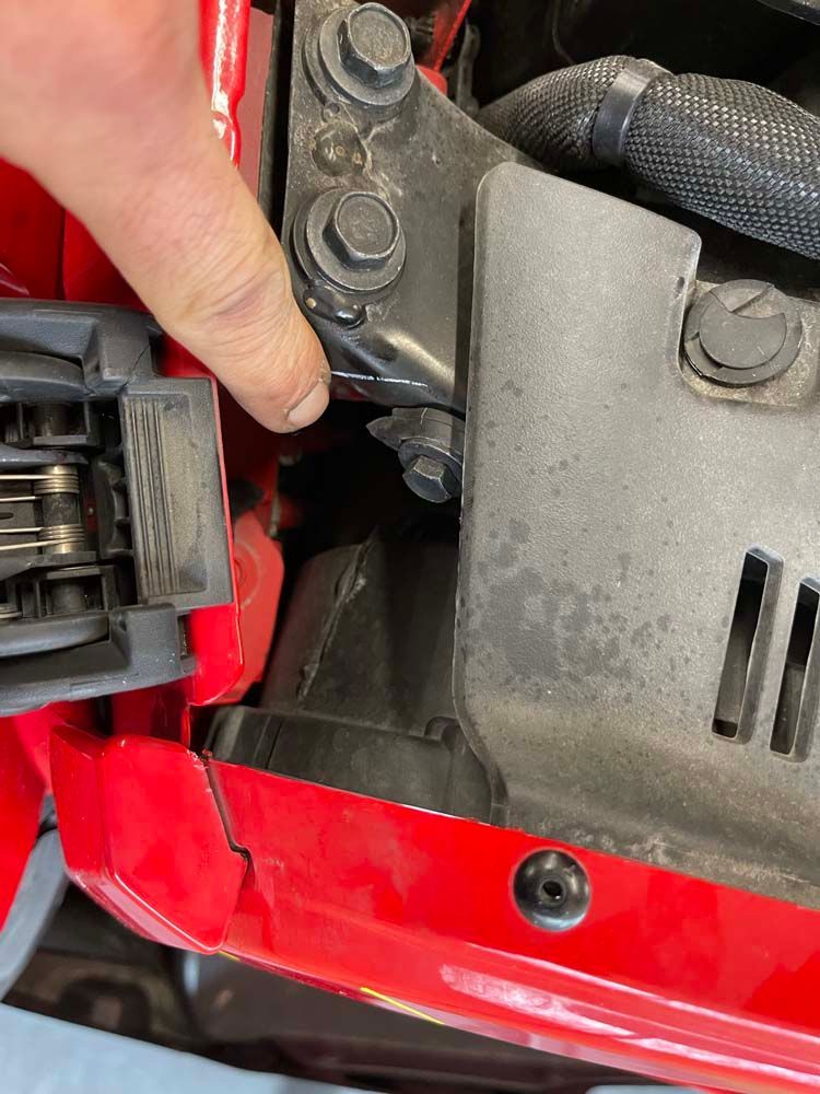 A close up of a person 's finger on a red car hood.