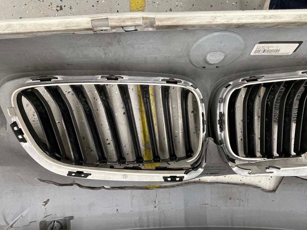 A close up of a bmw bumper with a grille on it.