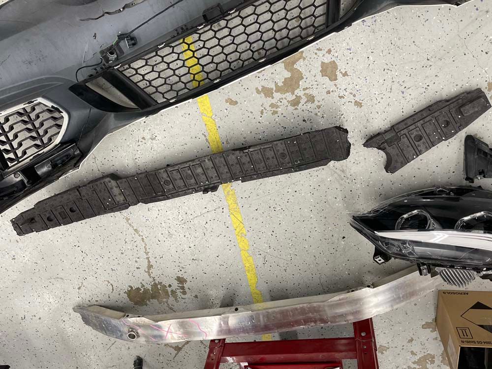 A bunch of car parts are laying on the floor.