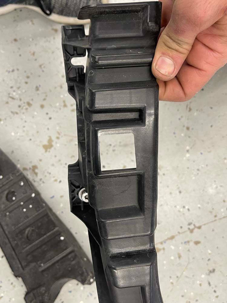 A person is holding a piece of plastic in their hand.