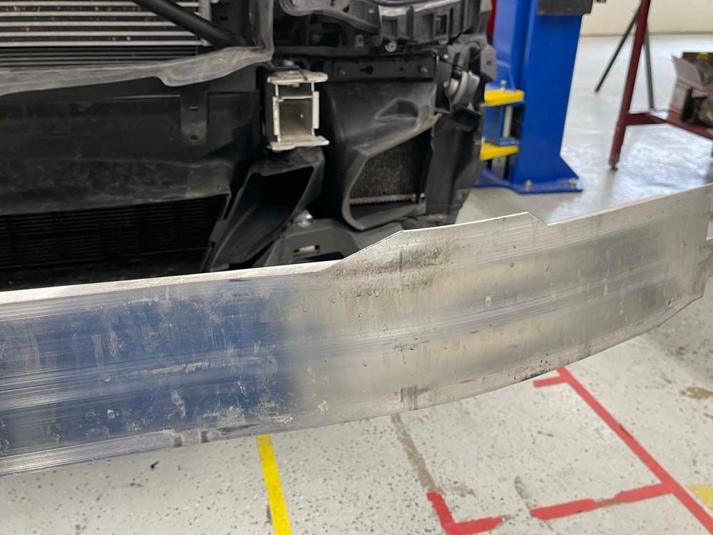 A close up of a bumper on a car in a garage.