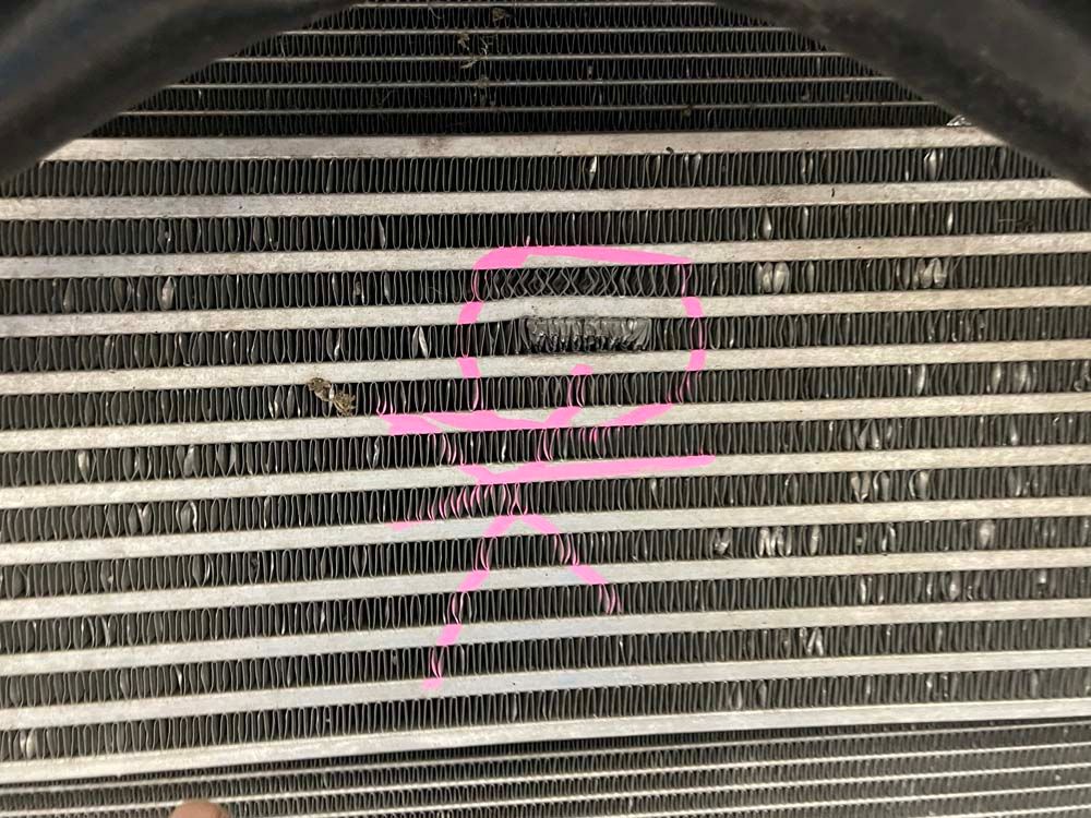A close up of a radiator with pink paint on it.