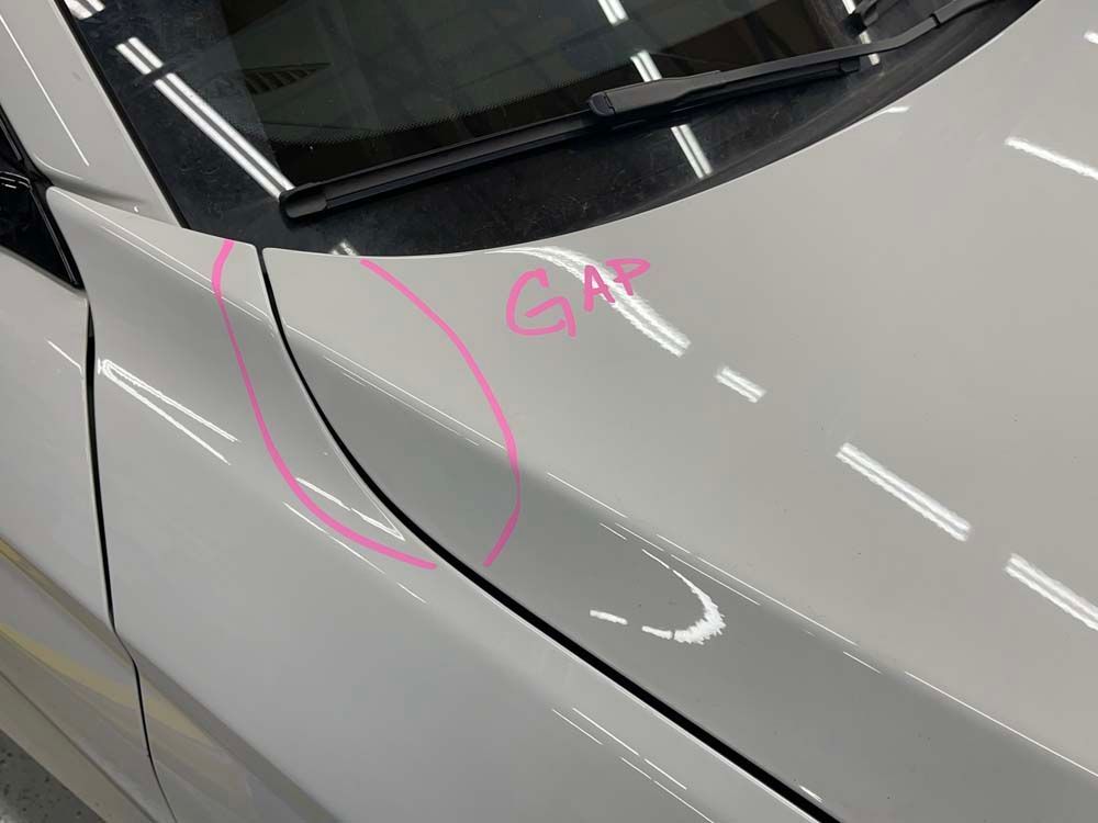 A close up of a white car with a pink circle drawn on it.