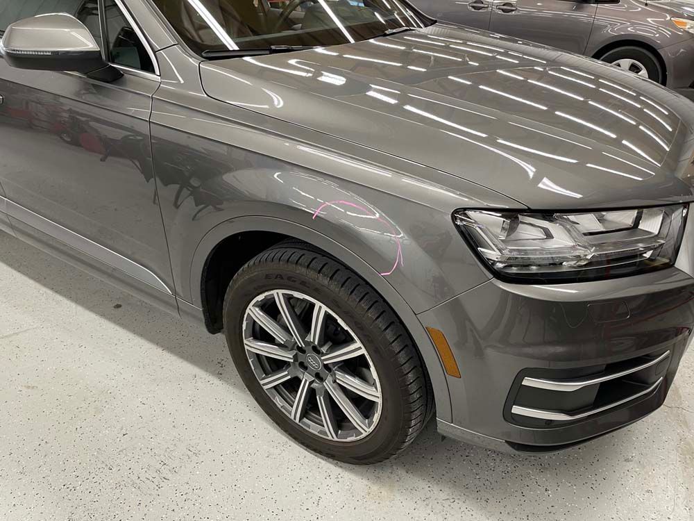 A gray audi q7 is parked in a showroom.
