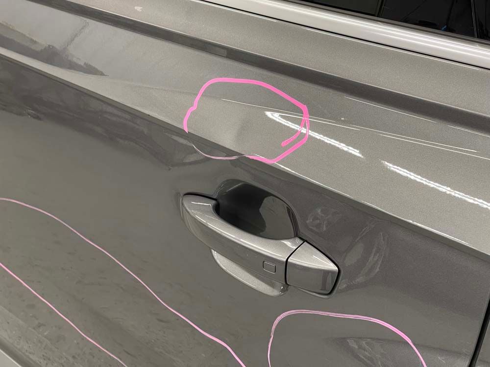 A close up of a car door with a pink circle drawn on it.