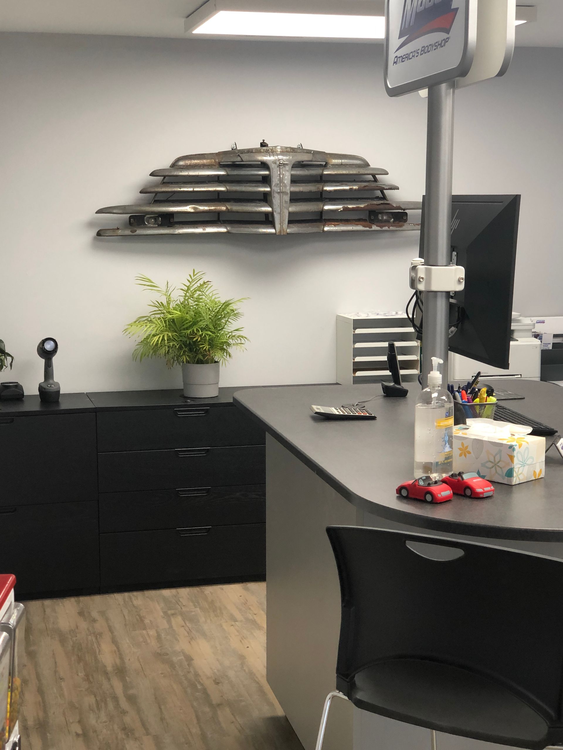 A desk with a monitor and a plant on it