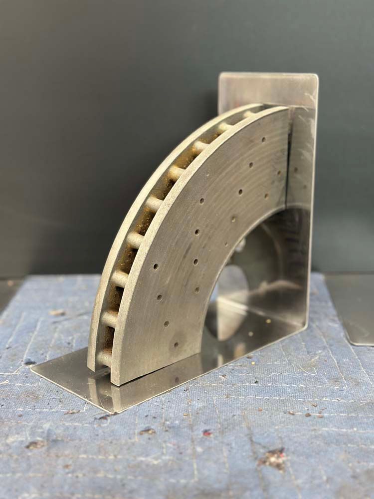 A stainless steel bookend in the shape of a brake disc