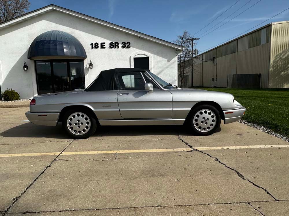 A silver car is parked in front of a building that says 18 e sr 32