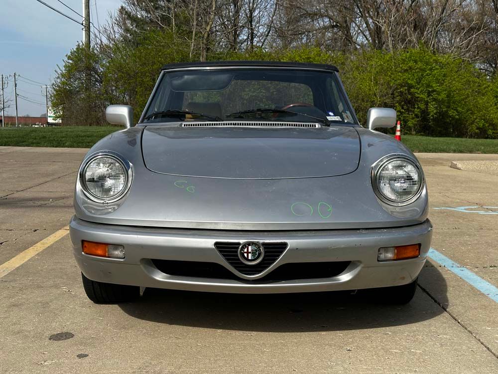 A silver car is parked in a parking lot.