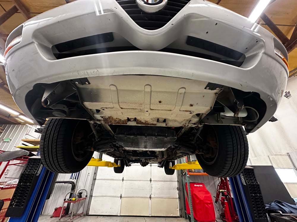 The underside of a car on a lift in a garage