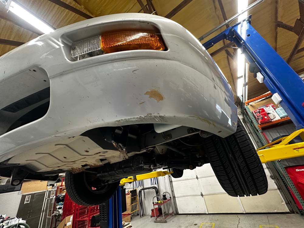 A car is sitting on a lift in a garage.