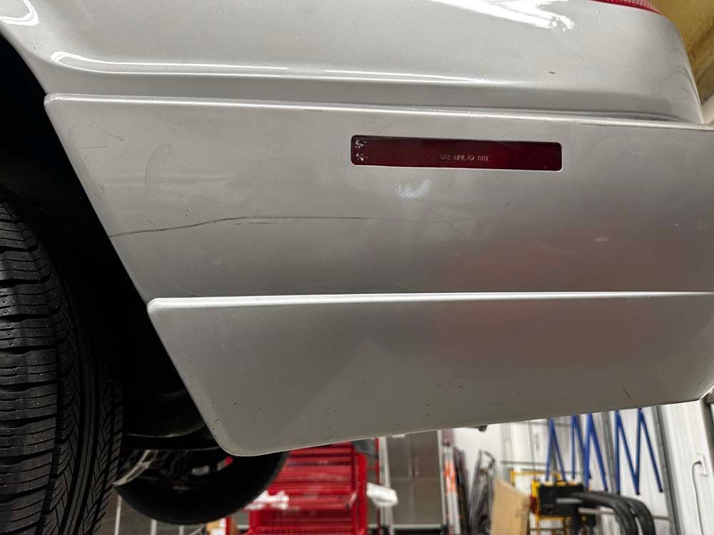 A close up of a car 's bumper in a garage.