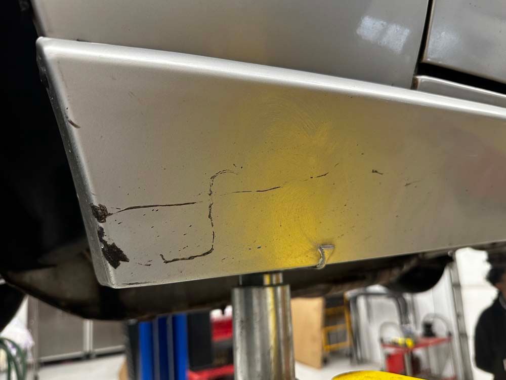 A car is sitting on a lift in a garage.