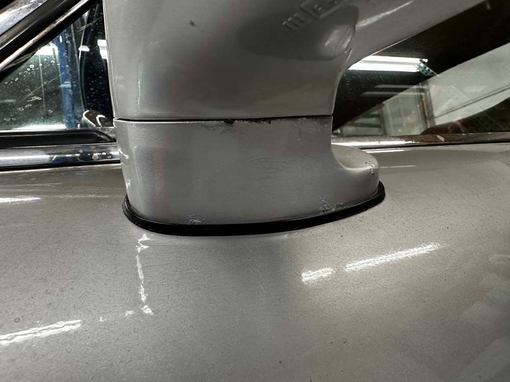 A close up of a side mirror on a silver car