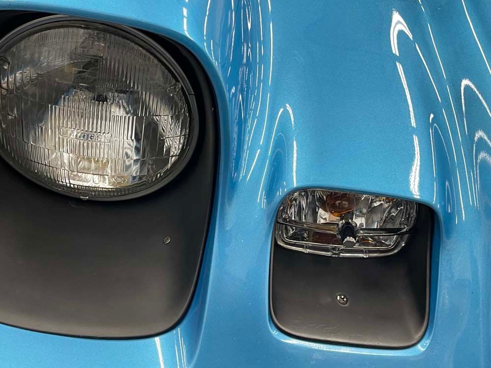 A close up of a blue car 's headlight