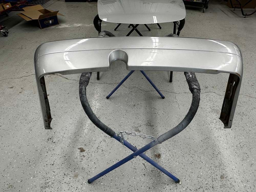 A car bumper is sitting on a stand in a garage
