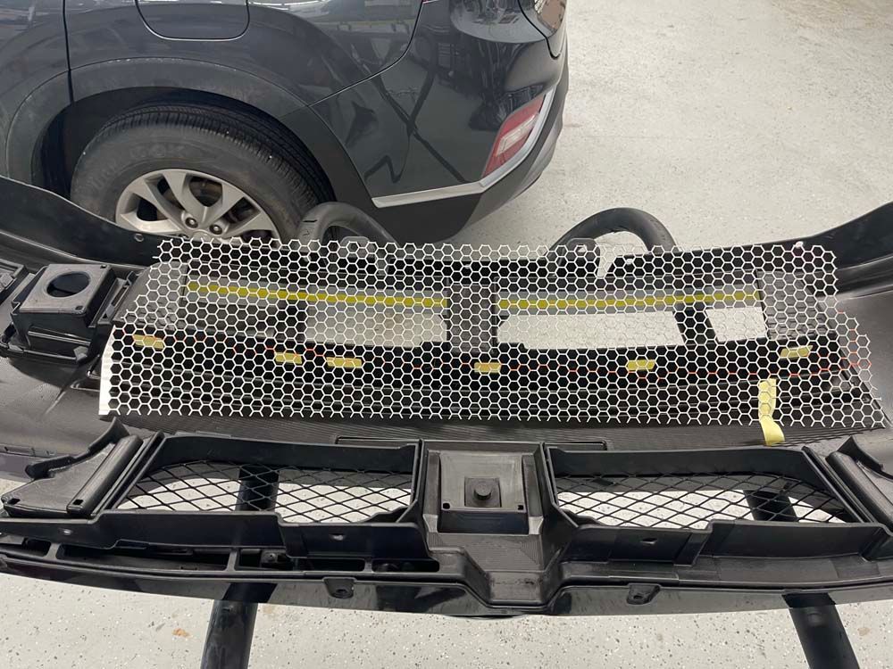 A black car is parked next to a black bumper.