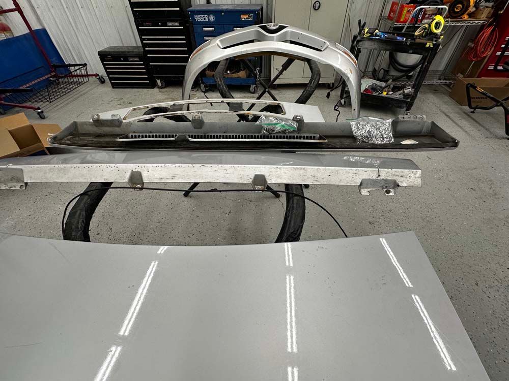 A car hood is sitting on a table in a garage.