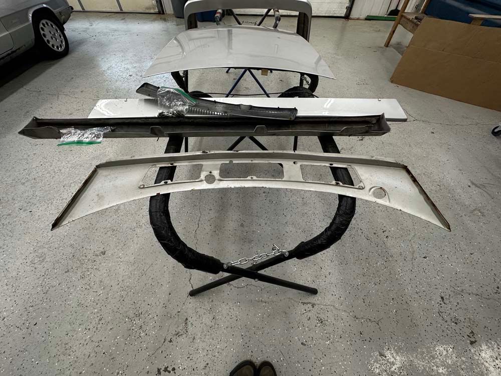 A bunch of car parts are sitting on a table in a garage.