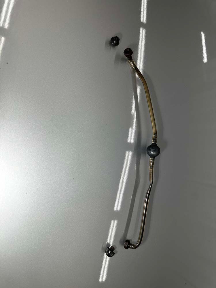 A metal pipe is sitting on top of a gray surface.