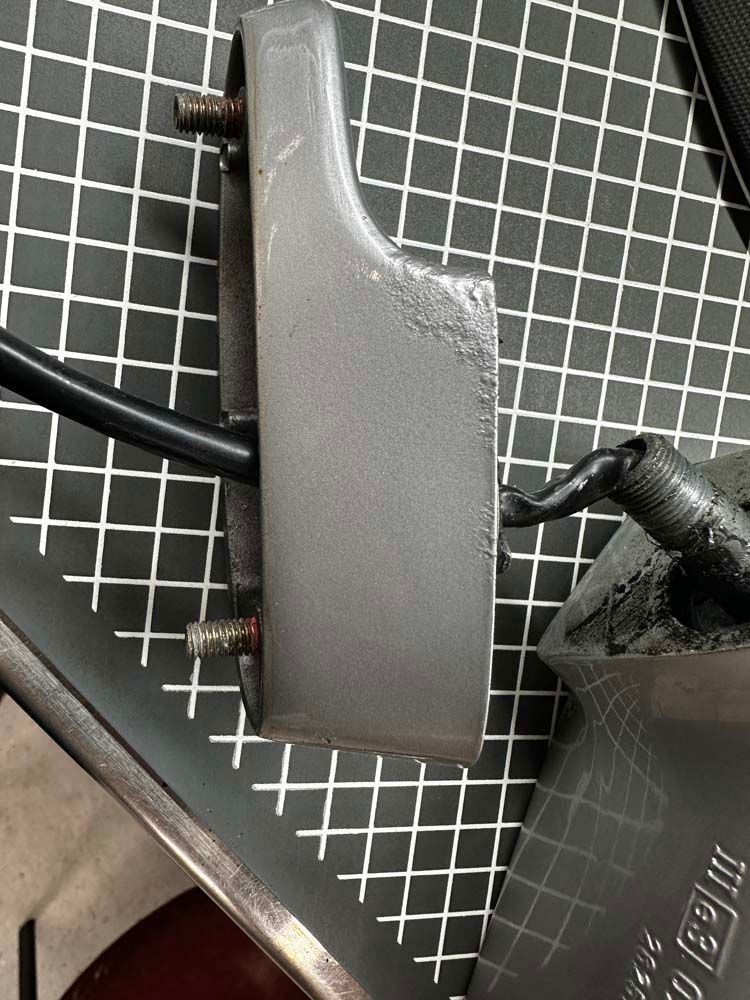 A piece of metal is sitting on top of a cutting board.