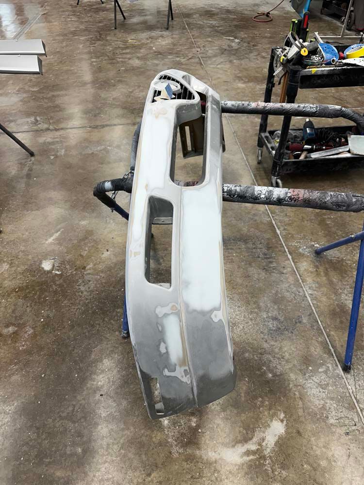 A bumper is sitting on a stand in a garage.