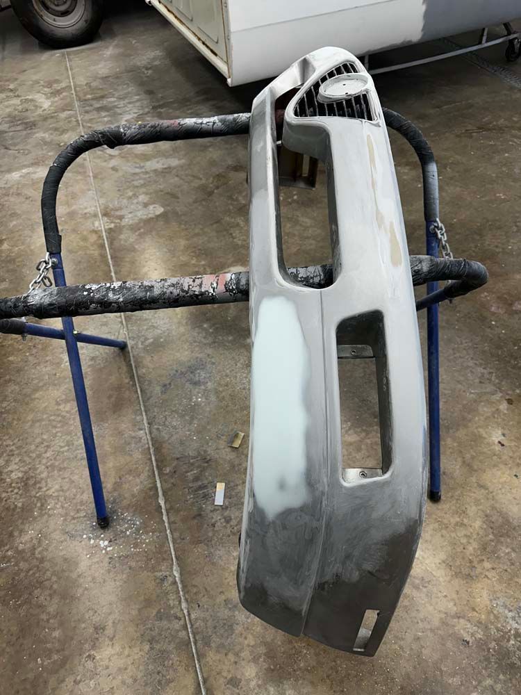 A bumper is sitting on a stand in a garage.