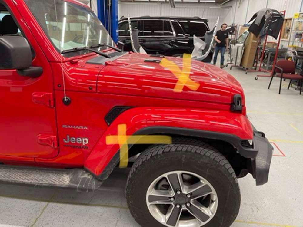 A red jeep with a yellow cross on the hood