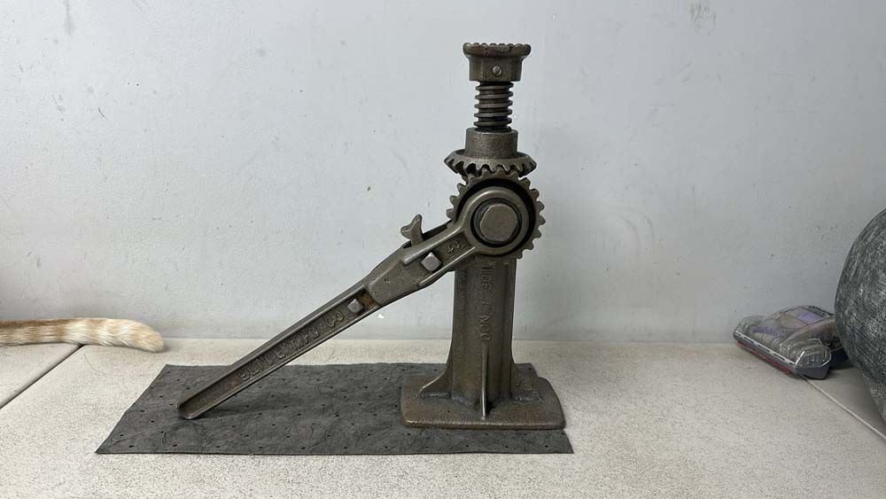 A metal jack is sitting on a mat on a table.