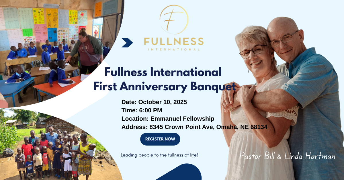 A woman in a red shirt and green jacket shakes hands with a child in a blue uniform in a school classroom. Two men in suits observe.