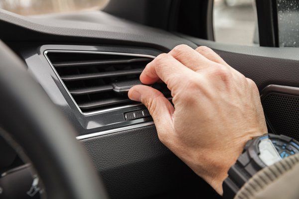 Man adjusting his Air Conditioning vent in his car