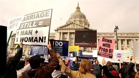 Protesters with signs in front of San Francisco City Hall, one sign reads