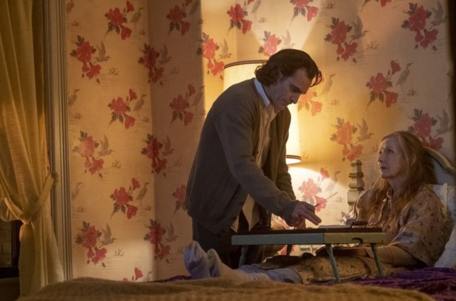 Ant-Man in his suit stands over fallen men in a metallic room, illuminated by geometric lights.