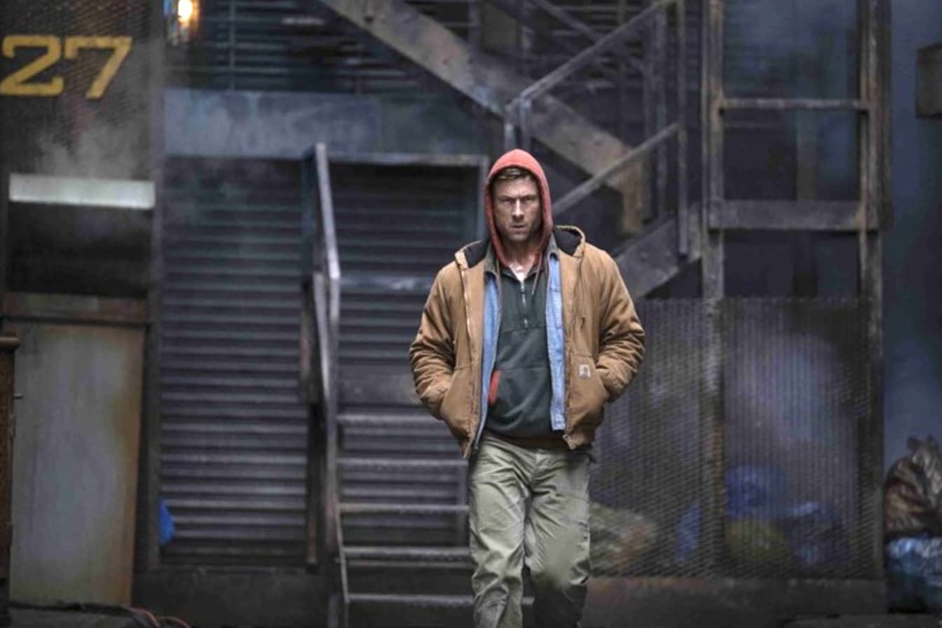 Woman smiling in a vintage airplane cockpit at an air show. Red scarf, blonde hair.