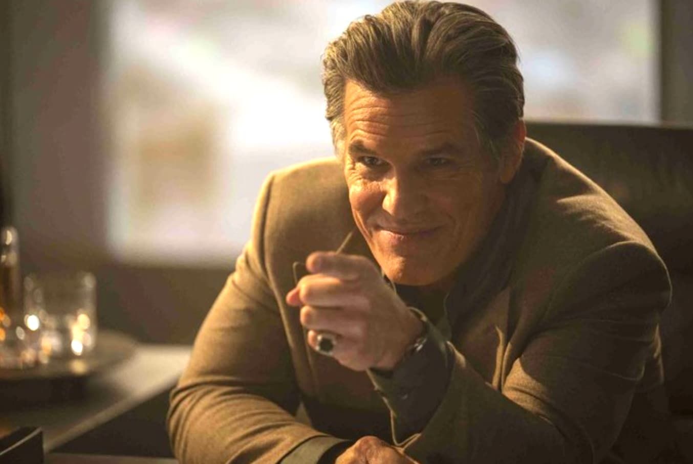 Richard Gere and a woman looking at blueprints in an airplane hangar.