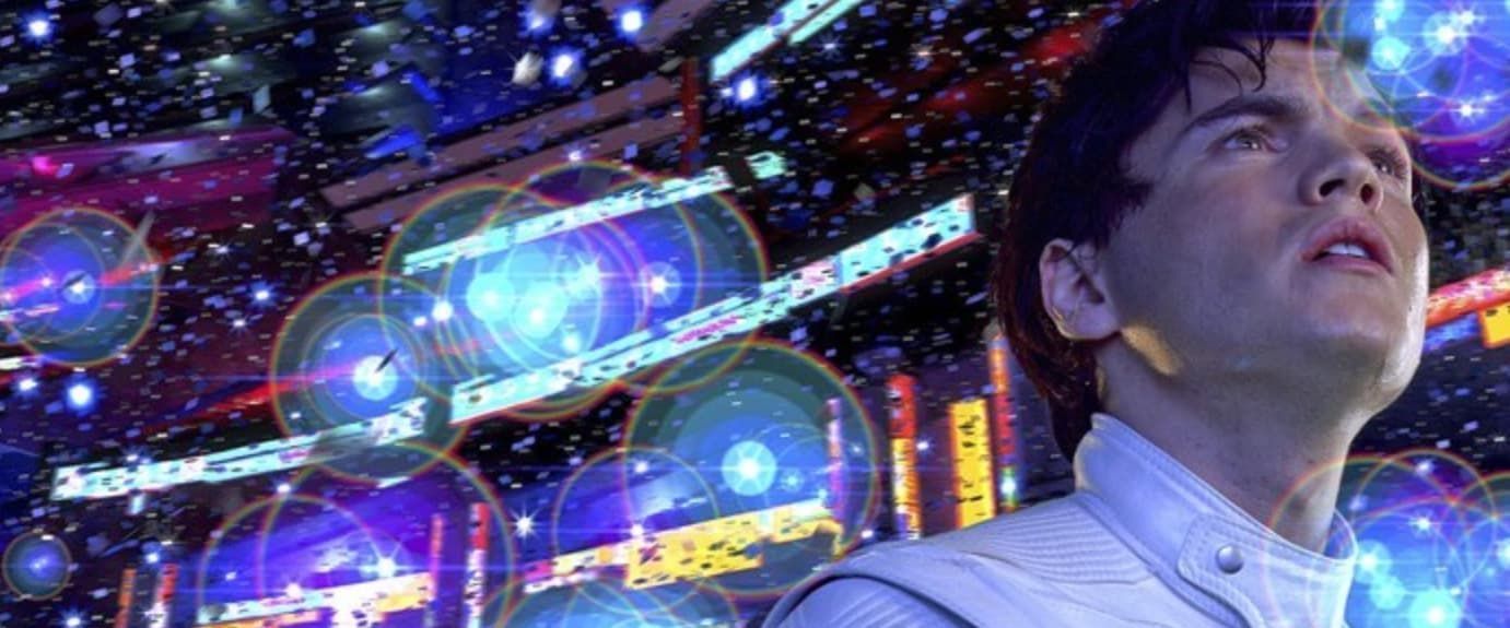 Speed Racer looking up amid glowing blue and purple city lights at night
