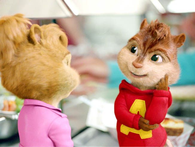 Alvin, a chipmunk in a red hoodie, smiles at a chipmunk with light brown hair wearing a pink shirt, inside a store.