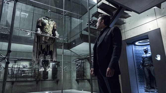 Michael Douglas in a convertible car, wearing sunglasses and a suit, looking to the side.