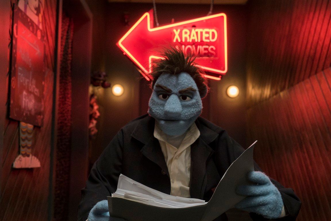 Blue Muppet, reading papers, under neon
