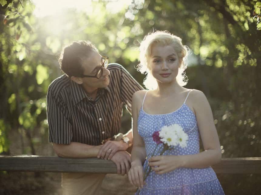 A man with glasses gazes at a blonde woman