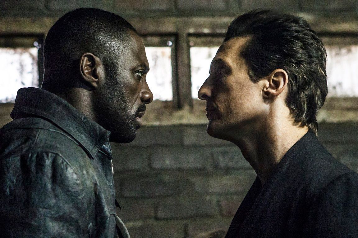 Two men face each other intensely. One is Black, the other white. They're in a dim, brick-walled space.